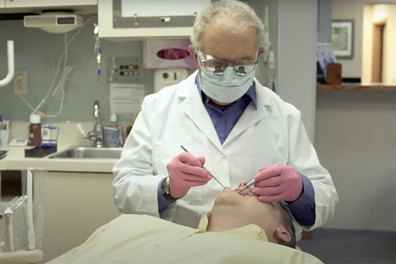 dentist, dr knellinger, performing implant procedure on patient