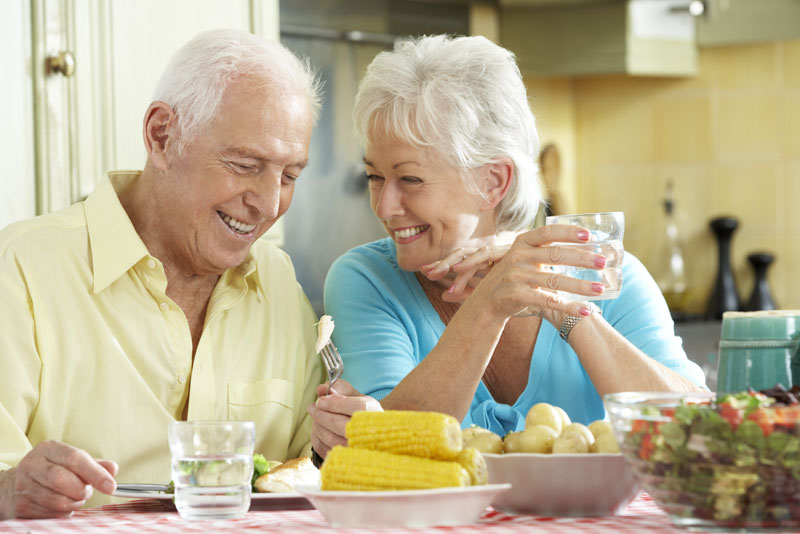 Dental Implant Patients Smiling While Eating Dinner Together