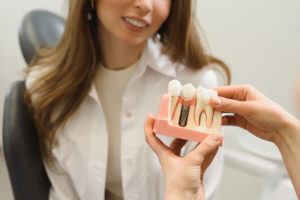 Dental Patient Getting Shown A Dental Implant Model During Her Consultation in Palm Harbor, FL